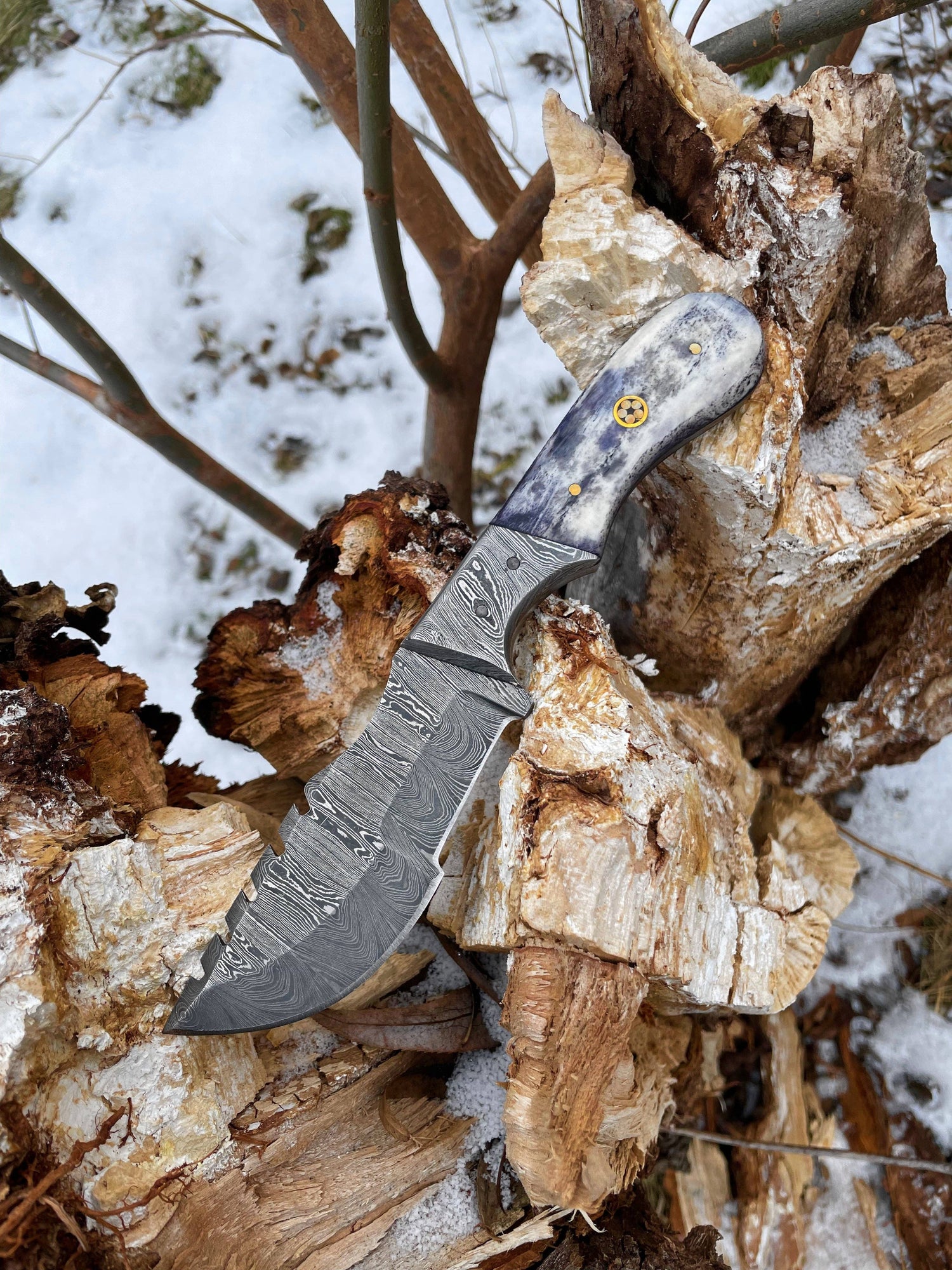 Knife on a pile of wood with a snowy background