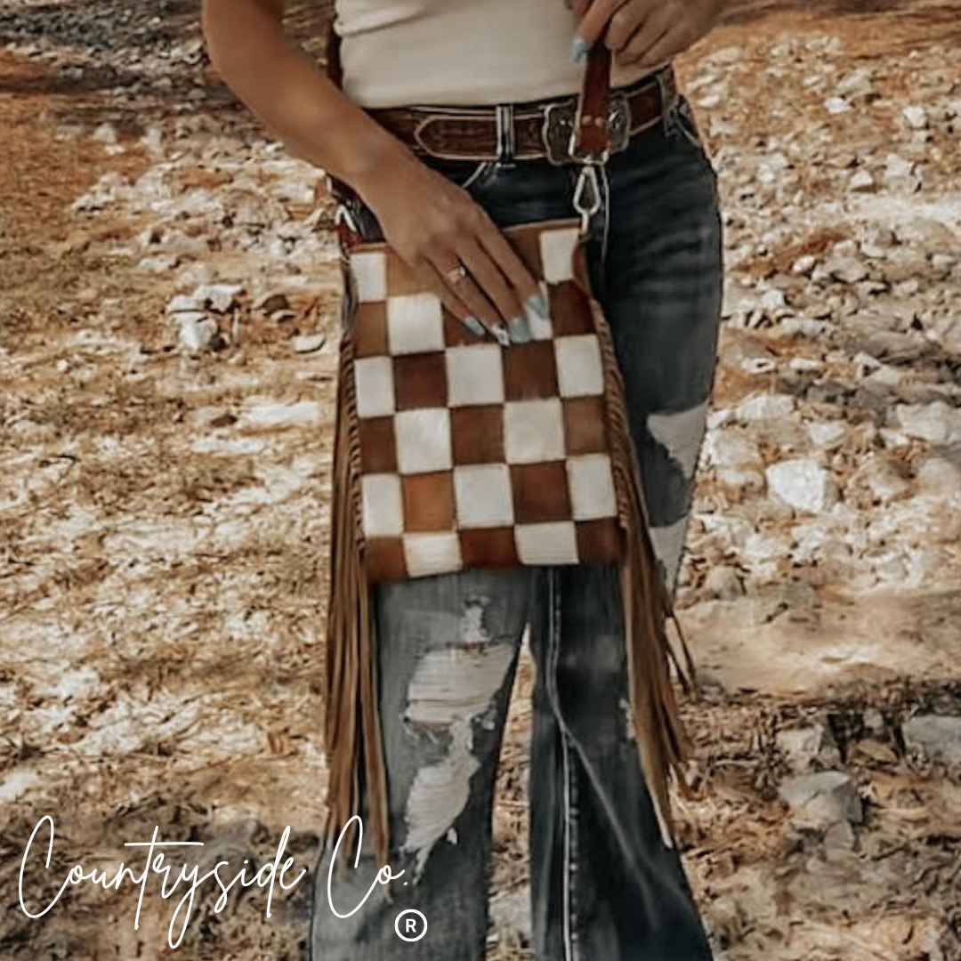Person holding a checkered bag with a rustic background, featuring 'Countryside Co' branding.