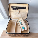Open jewelry case with turquoise earrings on a wooden surface