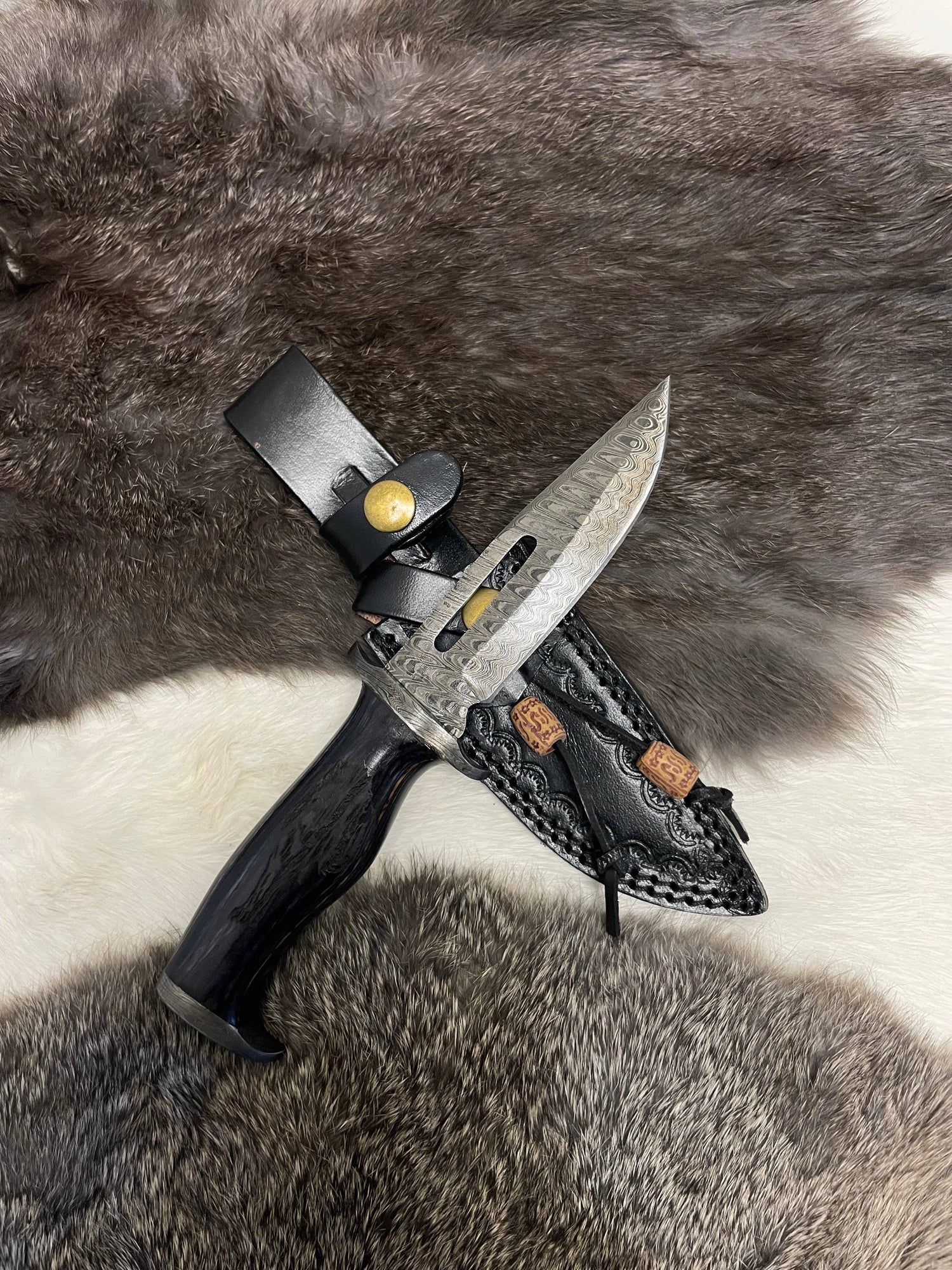 Knife with leather sheath on a fur background