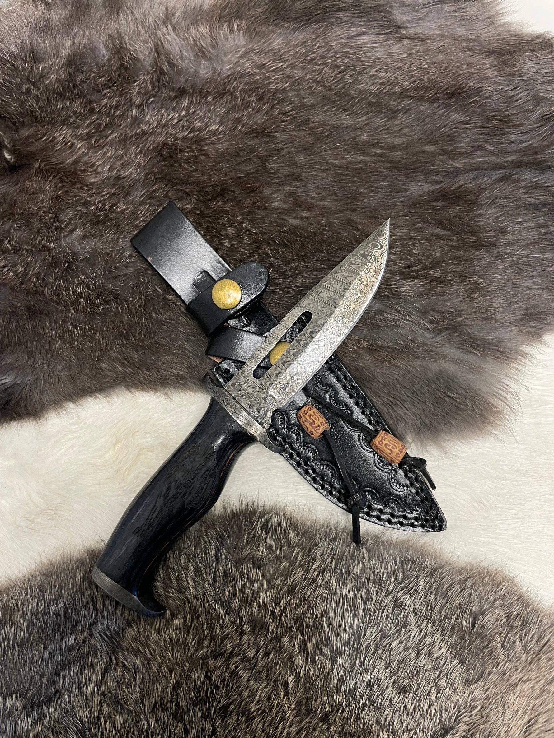 Knife with leather sheath on a fur background
