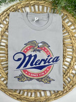 Gray sweatshirt with 'Merica' graphic design on a woven mat
