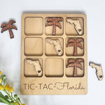 Wooden tic-tac-toe board with Florida and palm tree shapes on a white background