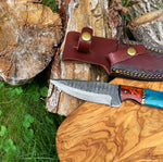 Knife with a wooden handle and leather sheath on a wooden surface