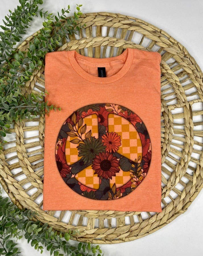 Orange tank top with a circular pattern on a woven mat with greenery