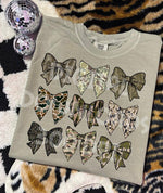 Gray sweatshirt with camouflage-patterned bows on a patterned surface