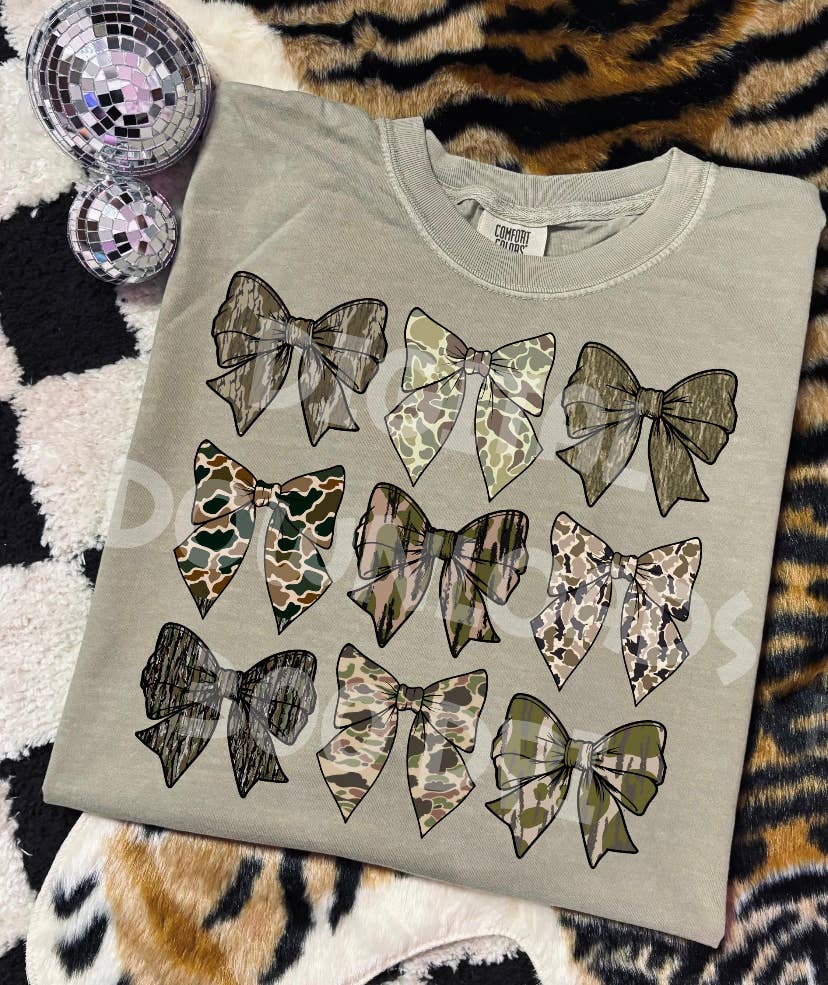 Gray sweatshirt with camouflage-patterned bows on a patterned surface