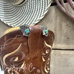 Brown leather boot with decorative elements on a wooden surface, featuring 'Countryside Co.' branding.