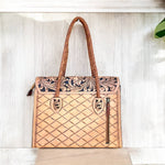 Leather handbag with intricate patterns on a light wooden surface