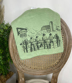Green t-shirt with a cowboy graphic on a wooden chair