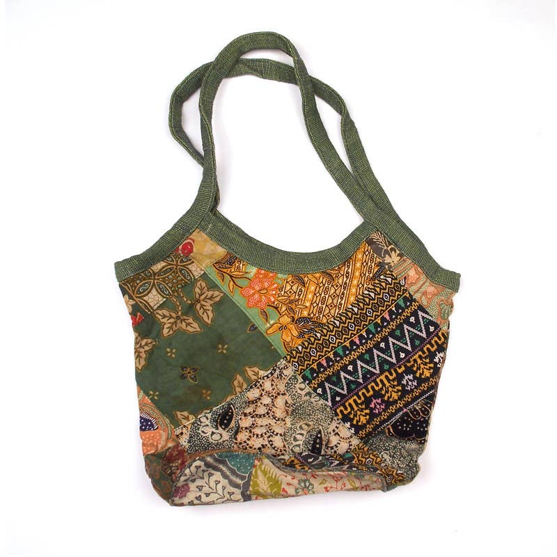 Multicolored patterned handbag with green strap on a white background