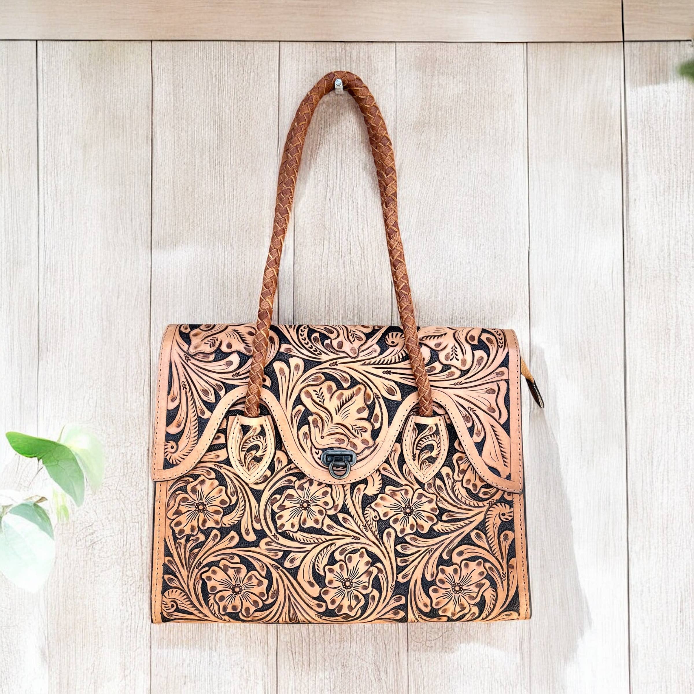 Handcrafted leather bag with intricate patterns on a wooden surface