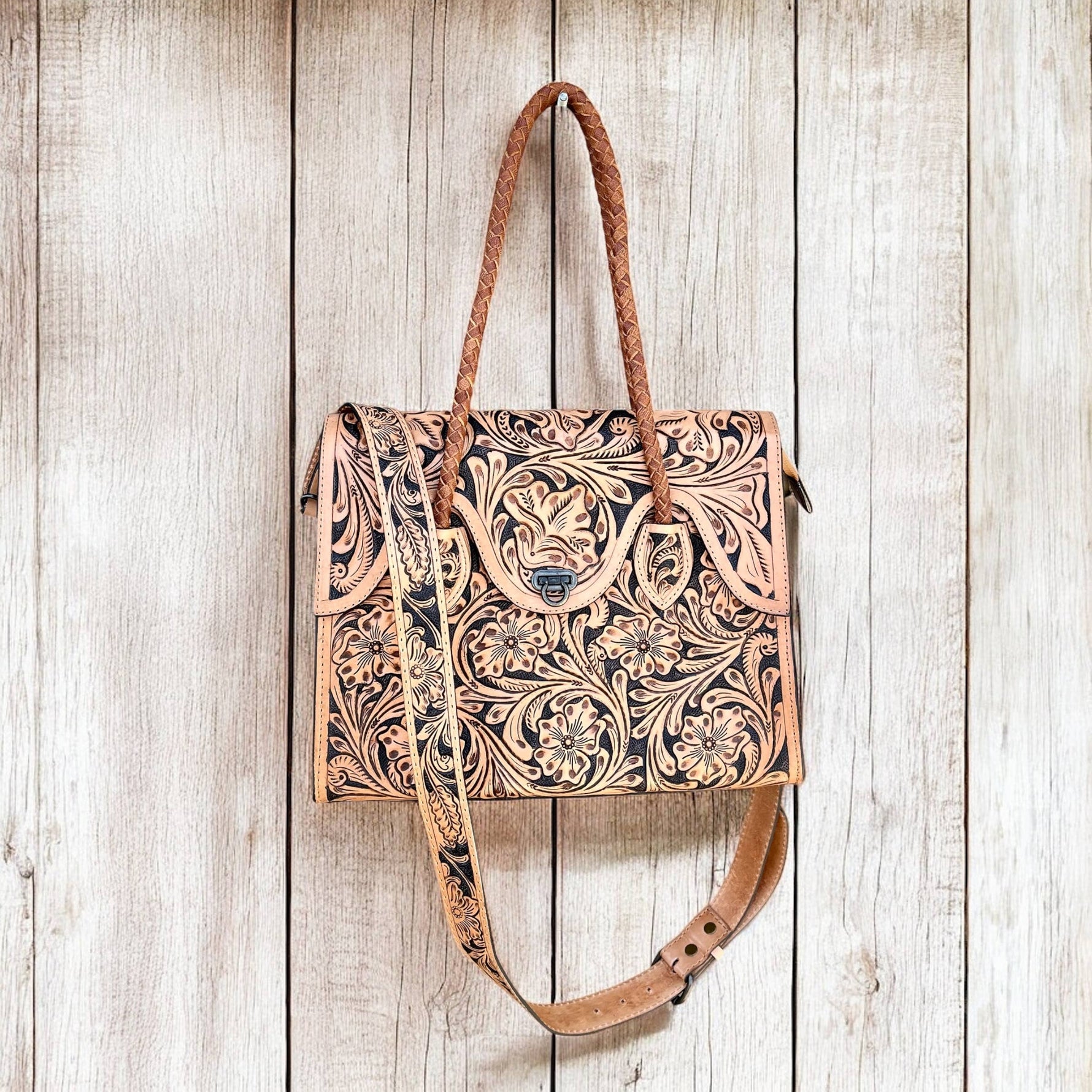 Leather handbag with intricate patterns on a wooden surface