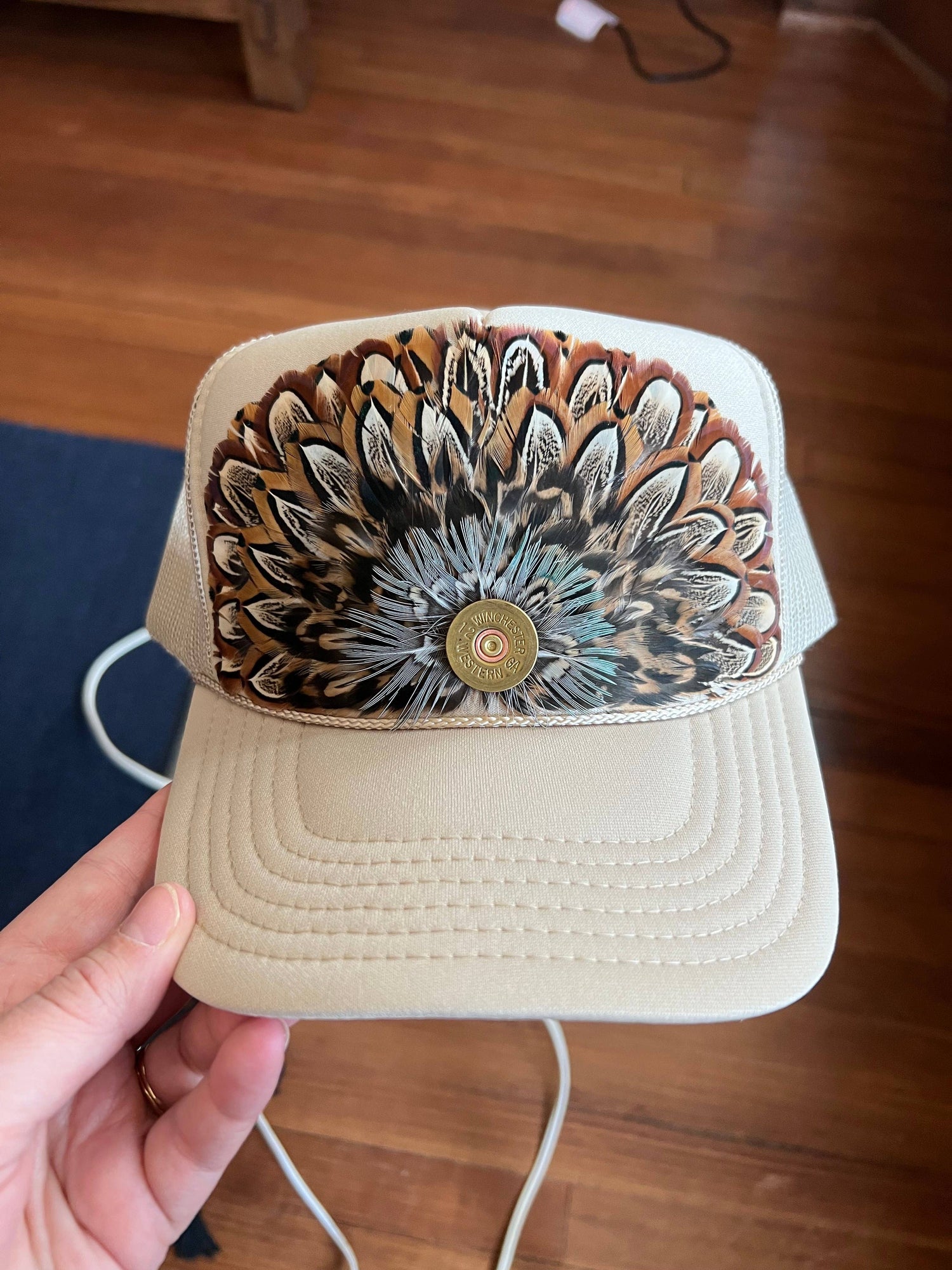 Beige cap with a decorative floral pattern on a wooden floor