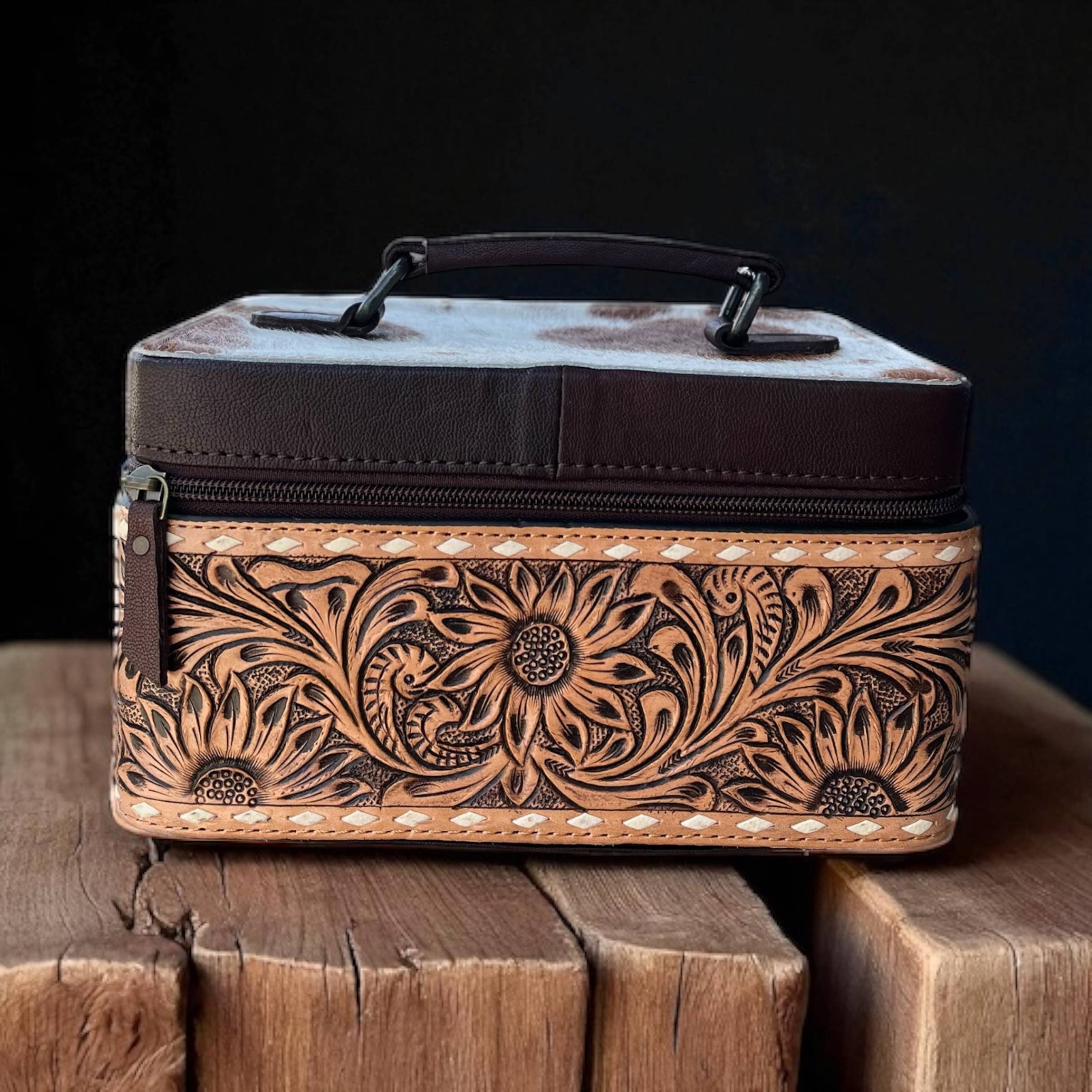 Decorative leather box with floral patterns on a wooden surface