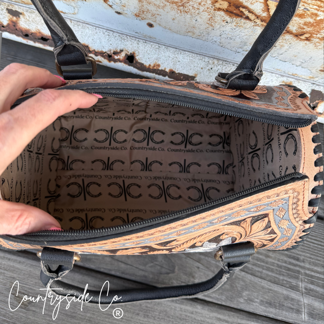 Close-up of a hand holding a patterned bag with visible branding.