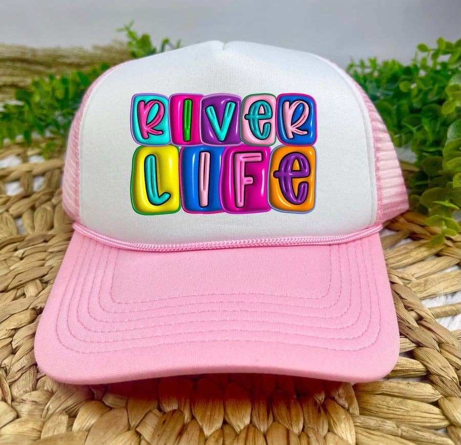 Pink and white cap with 'River Life' text in colorful letters on a woven surface.