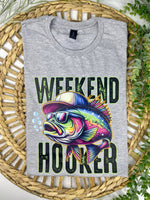Gray t-shirt with a colorful fish graphic and 'Weekend Hooker' text on a woven mat.