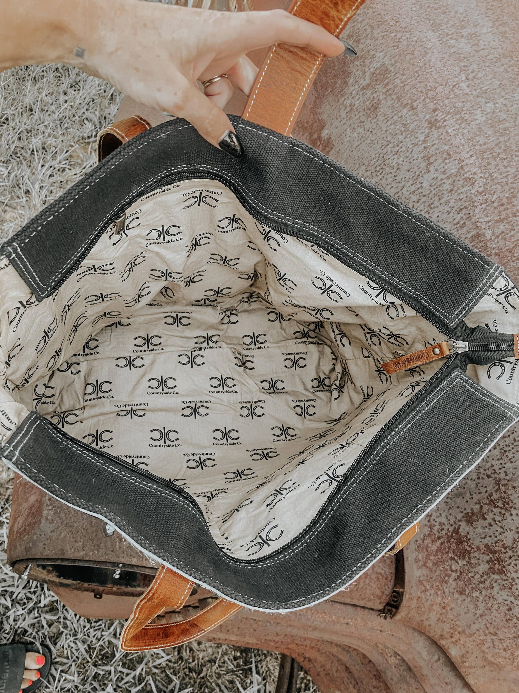 Close-up of a handbag with a patterned interior on a textured surface