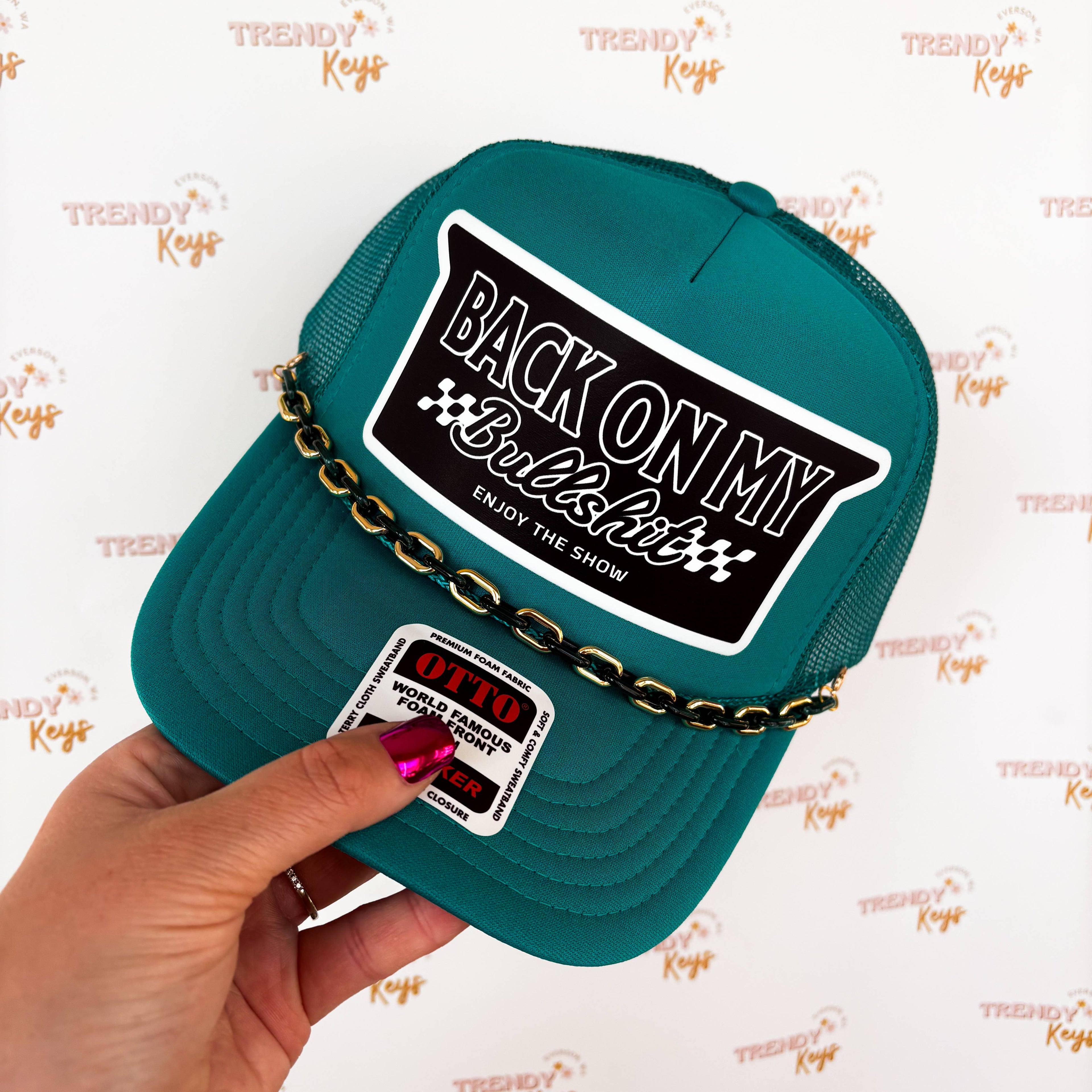 Teal cap with text and chain held by a hand on a white background with 'Trendy Keys' branding.