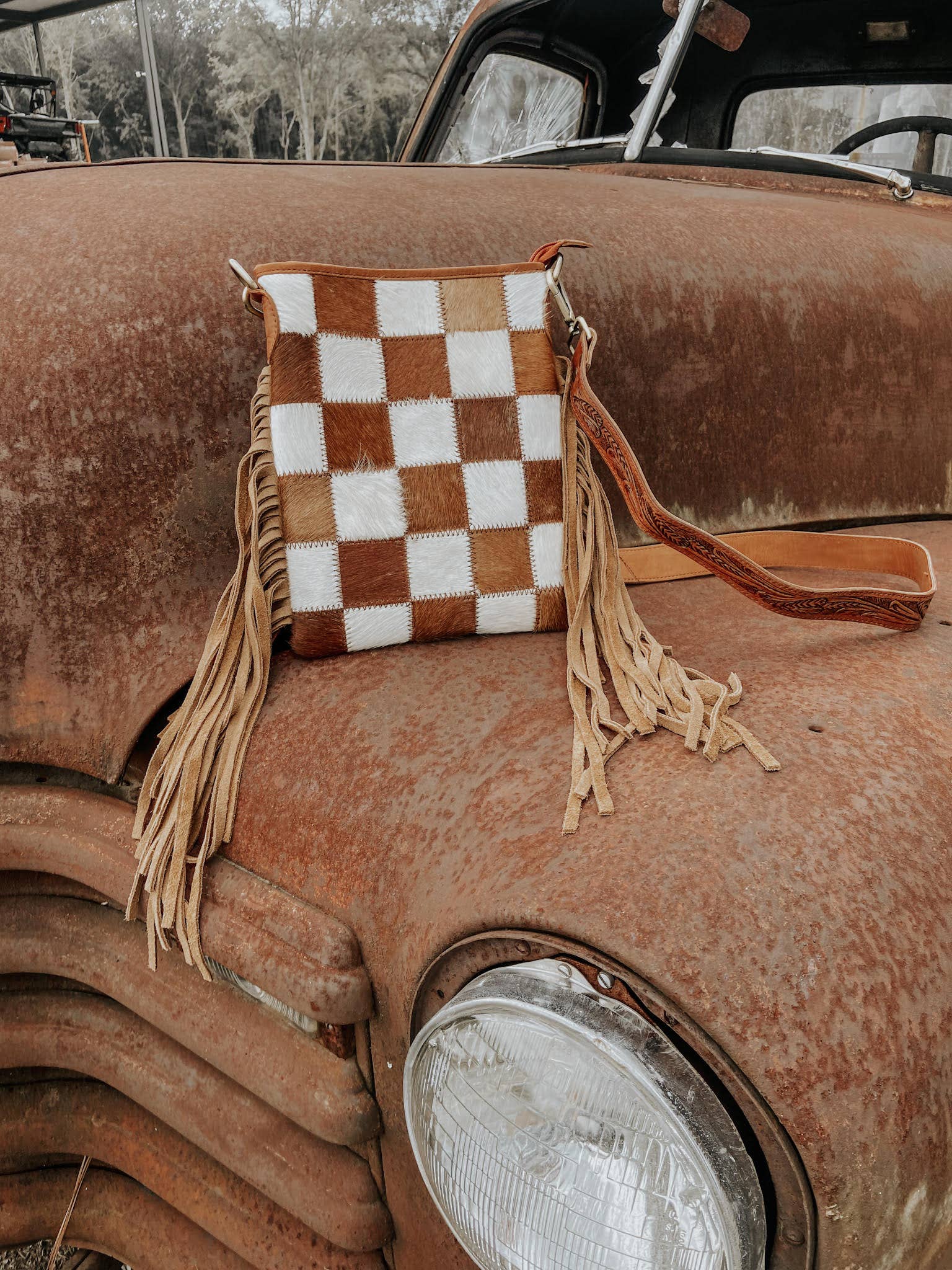 Checkered bag with fringes on a rusty vintage car